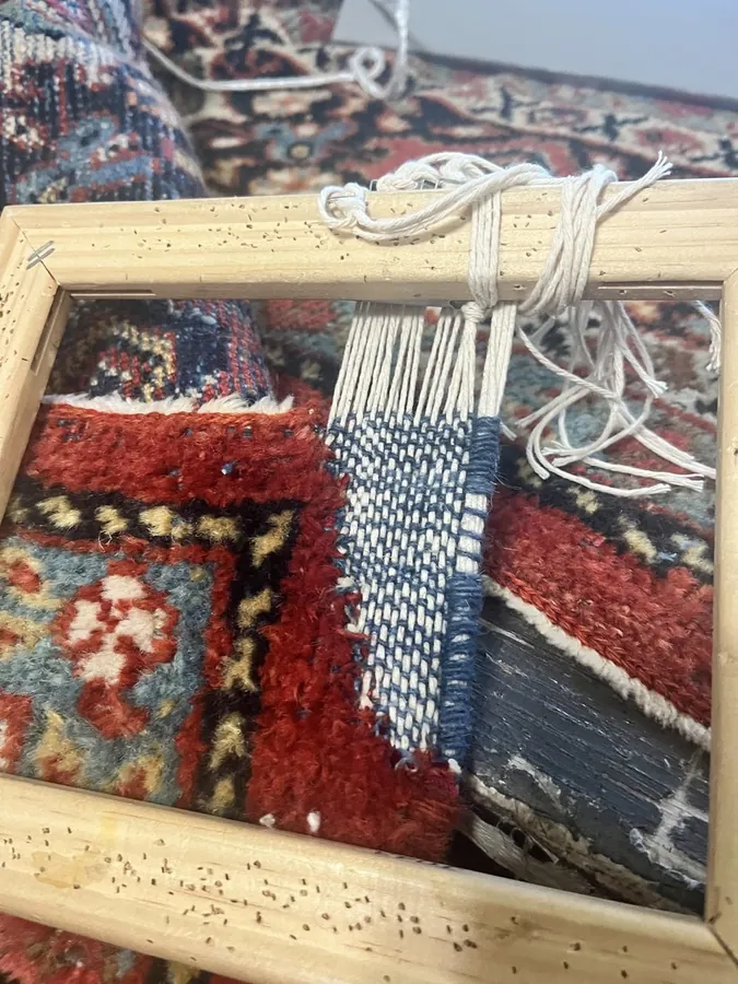 Warp threads hand-woven back in on a restoration loom